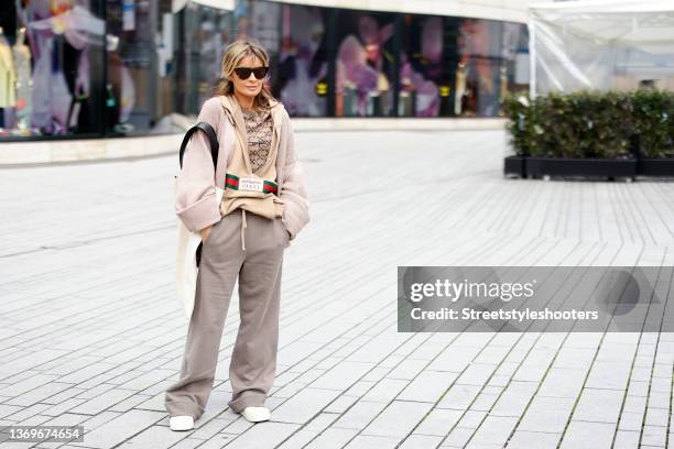 Influencer Gitta Banko wearing a beige pullover by Off-White, a beige hoodie with front zipper by Gucci, a beige knitted jacket by Off-White and...