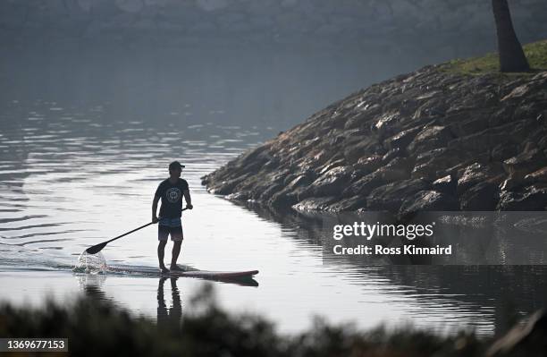 Fan on a paddleboard watches the action on the 11th hole during day one of the Ras Al Khaimah Classic at Al Hamra Golf Club on February 10, 2022 in...