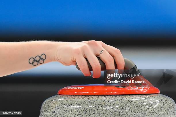 Detail of the Olympic rings' tattoo of Sara McManus of Team Sweden is seen as she curls the stone against Team Japan during the Women's Round Robin...