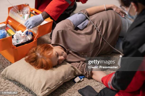 paramedic measuring blood pressure of woman in diabetic coma - coma stock pictures, royalty-free photos & images