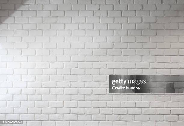 white bricks wall with light and shadow. abstract background. - brick wall stockfoto's en -beelden