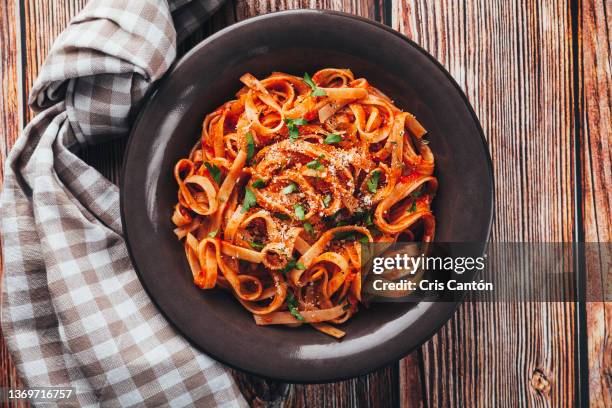 tagliatelle  with tomato sauce on wooden background. - pasta stockfoto's en -beelden