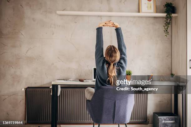 ホーム オフィスで働く女性 - stretching ストックフォトと画像
