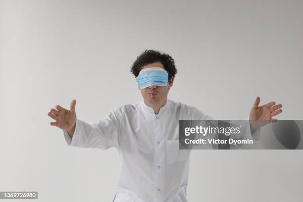 man in the medical uniform with facial mask on his eyes - wrong way stockfoto's en -beelden