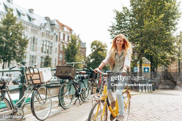 beautiful woman walking with the bike in amsterdam - daily life in amsterdam imagens e fotografias de stock