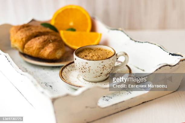coffee cup on saucer, croissant, fresh orange on white shabby chic wooden tray. morning breakfast - shabby chic stockfoto's en -beelden