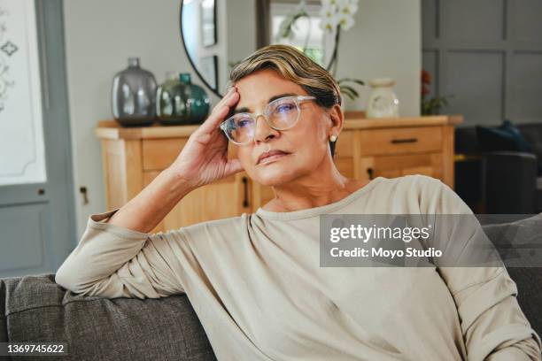 shot of a mature woman looking unhappy at home - shameful stock pictures, royalty-free photos & images