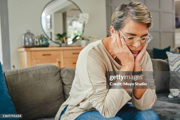 aufnahme einer reifen frau, die zu hause unglücklich aussieht - studio shot lonely woman stock-fotos und bilder