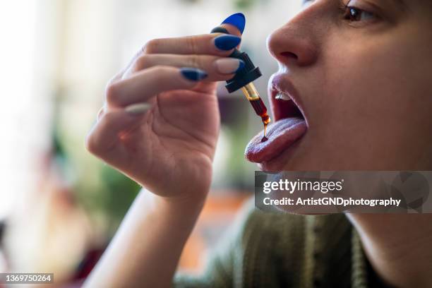 self medication of cbd oil using a dropper. - cbd oil stock pictures, royalty-free photos & images