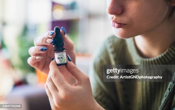 woman holding cbd oil container. - cbd oil stock pictures, royalty-free photos & images