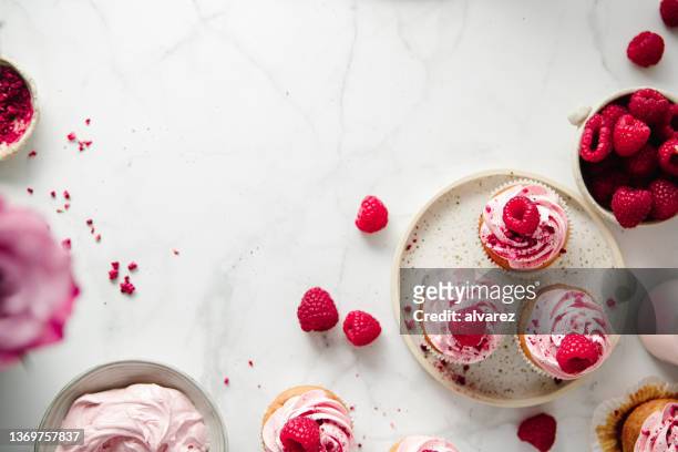 freshly prepared raspberry cupcakes on kitchen counter - efterrätt bildbanksfoton och bilder