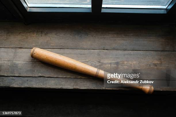 a wooden baseball bat is lying on a table or windowsill. the concept of sports play and leisure, entertainment and competitions, self-defense, defense and protection. - 野球とクリケットのバット ストックフォトと画像