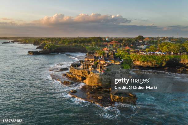 sunset over the tanah lot temple in bali, indonesia - bali indonesia stock pictures, royalty-free photos & images