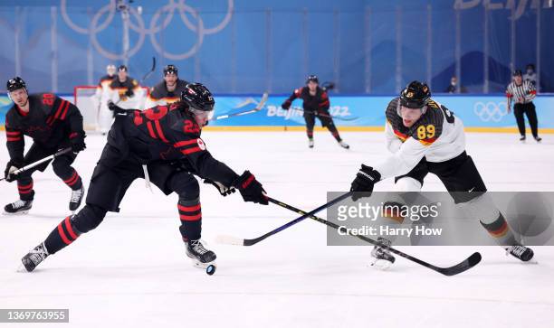 Owen Power of Team Canada and David Wolf of Team Germany battle for the puck during the second period of the Men's Ice Hockey Preliminary Round Group...