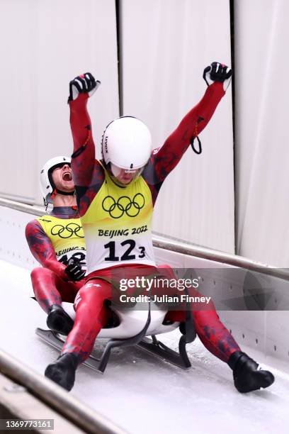 Martins Bots and Roberts Plume of Team Latvia react after sliding during the Luge Team Relay on day six of the Beijing 2022 Winter Olympics at...