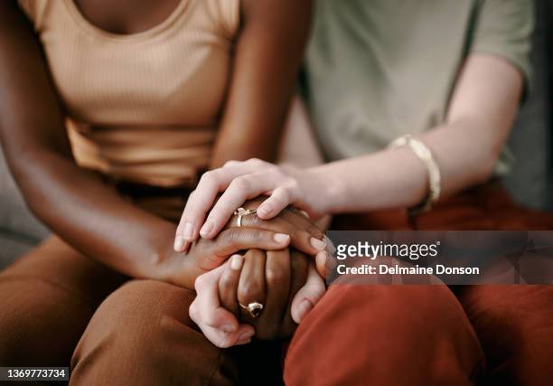shot of two friends holding hands supporting one another - emotional support stock pictures, royalty-free photos & images