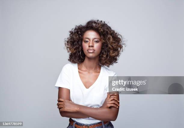 joven confiada con camiseta blanca - afro fotografías e imágenes de stock