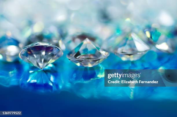 tiny glass gems on blue holographic foil, copy space on image. - forma de diamante fotografías e imágenes de stock