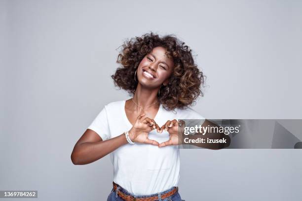 happy young woman in white t-shirt - woman index finger stock pictures, royalty-free photos & images