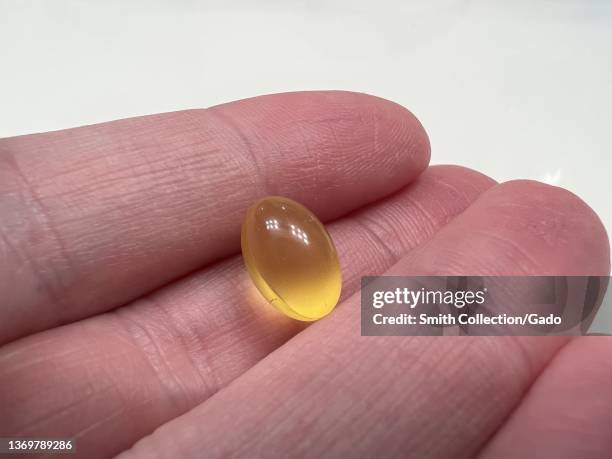 Person's hand holding a small Vitamin D pill or supplement, Lafayette, California, January 4, 2022.