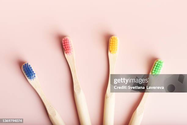 four eco friendly natural bamboo toothbrushes on pink background. - plastic free stock pictures, royalty-free photos & images