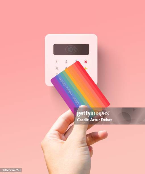 paying to wireless point of sale (pos) (pop) reader using colorful rainbow credit card. - point of sale stock pictures, royalty-free photos & images
