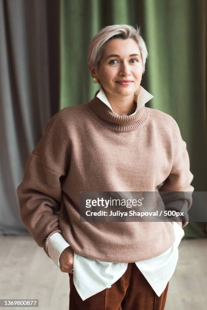 fashion woman in brown oversize sweater and trousers standing in - bigger photos et images de collection