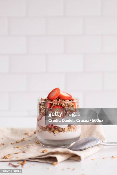 yogurt and granolas,close-up of dessert in bowl on table - strawberries and cream stockfoto's en -beelden