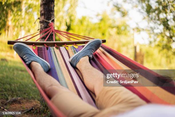 pov of unrecognizable man, lying in the hammock, and enjoy a carefree summer day - backyard hammock stock pictures, royalty-free photos & images