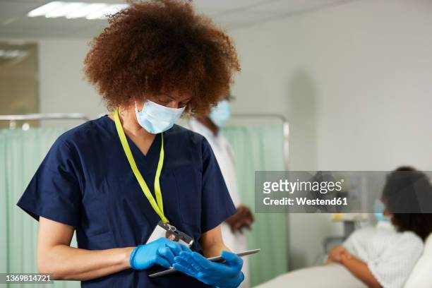 female nurse using tablet pc in medical room - coronavirus england stock pictures, royalty-free photos & images