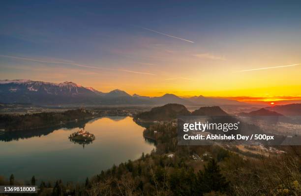 bled with the rising sun,scenic view of lake against sky during sunset,bled,slovenia - lake bled stockfoto's en -beelden