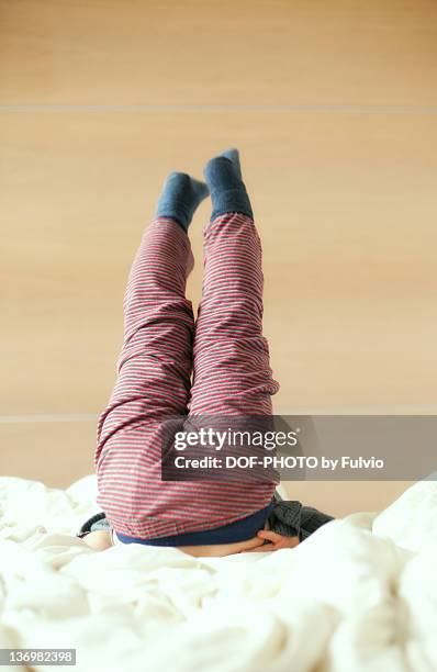 little boy jumping on bed - a boy jumping on a bed fotografías e imágenes de stock