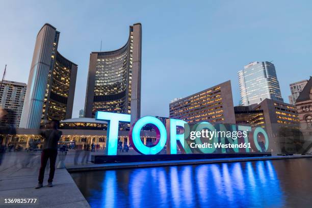 canada, ontario, toronto, long exposure of 3d toronto sign in nathan phillips square at dusk - praça nathan phillips - fotografias e filmes do acervo