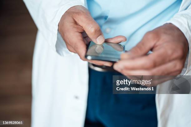 doctor using smart phone in hospital - doctor phone stock pictures, royalty-free photos & images