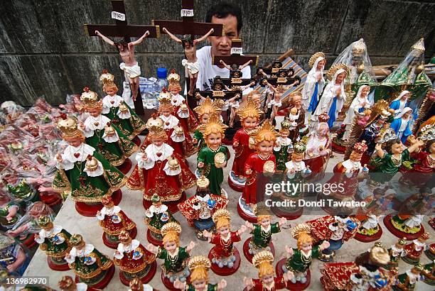 Vendors sell various religious images of the Child Jesus outside the Santo Nino Church in the urban area of Tondo on January 14, 2012 in Manila,...