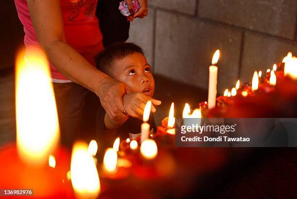 Catholic devotees light candles to mark the feast of Sto Nino in the urban area of Tondo on January 14, 2012 in Manila, Philippines. Residents and...