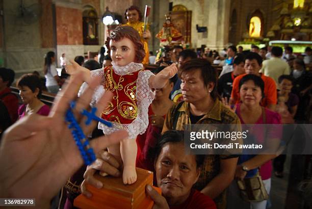 Catholic devotees hold a religious image of the Child Jesus to celebrate the grand procession of the feast of Santo Nino dubbed "Lakbayaw" from the...