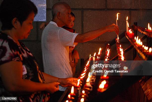 Catholic devotees light candles to mark the feast of Sto Nino in the urban area of Tondo on January 14, 2012 in Manila, Philippines. Residents and...