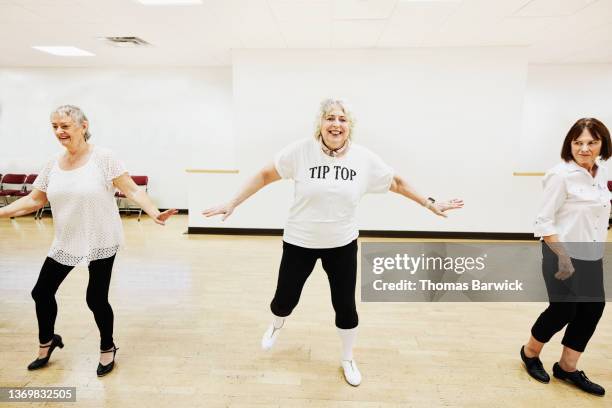 wide shot of smiling senior women in tap dance class in studio at retirement community center - tap dancing stock pictures, royalty-free photos & images