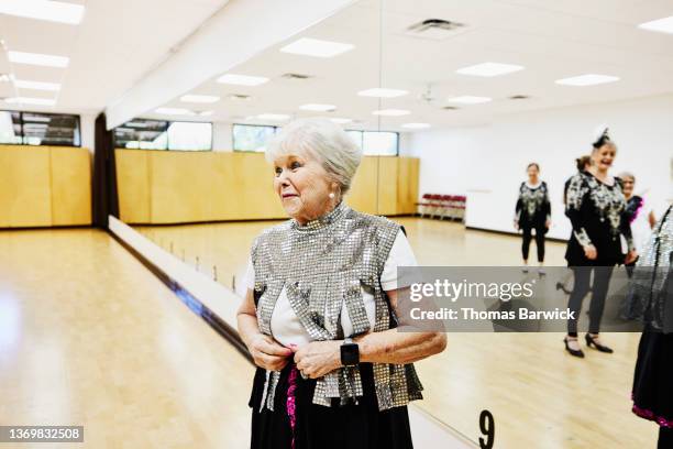 wide  shot of smiling senior female tap dancer in costume in dance studio before rehearsal at retirement community center - dancing studio shot stock pictures, royalty-free photos & images