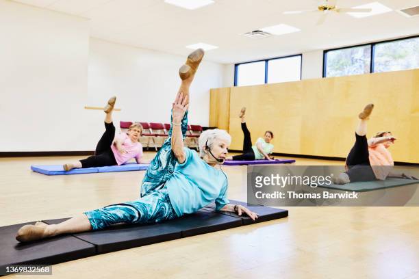 Wide shot of senior woman leading exercises during fitness class at retirement community center