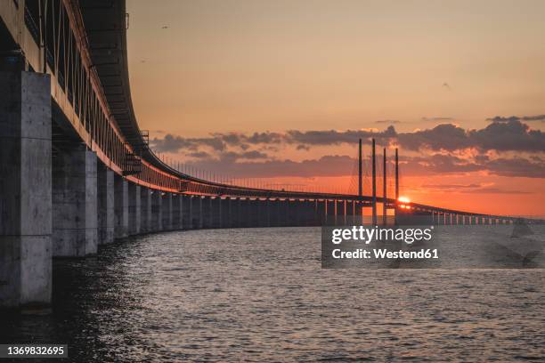 sweden, skane county, malmo, oresund bridge at sunset - oresund bridge stock pictures, royalty-free photos & images