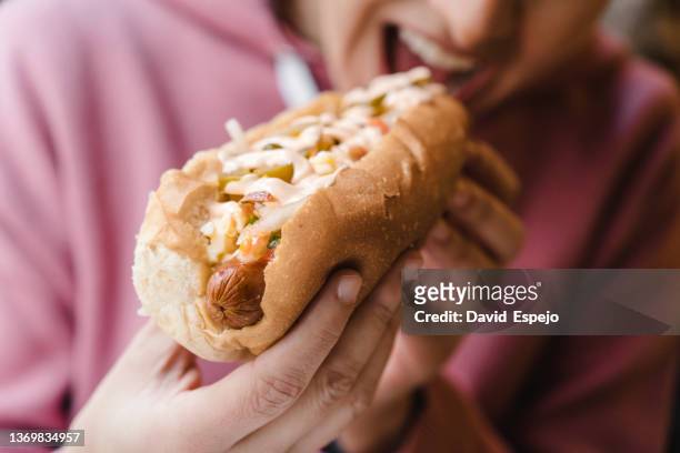 close up view of a woman enjoying eating a delicious hot dog. - hot latina women 個照片及圖片檔