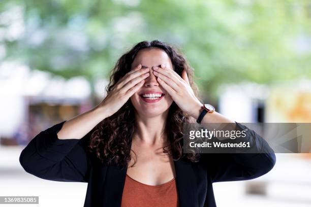 happy businesswoman covering eyes with hands - augen zuhalten stock-fotos und bilder