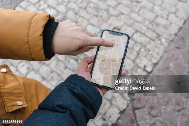 two people using mobile phone gps navigation map on the street. - madrid map stock pictures, royalty-free photos & images