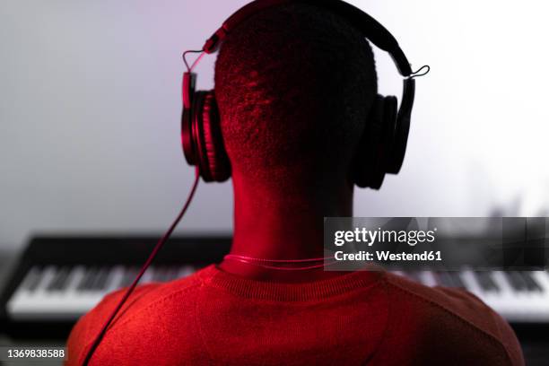 man wearing headphones in front of piano - practicing piano stock pictures, royalty-free photos & images