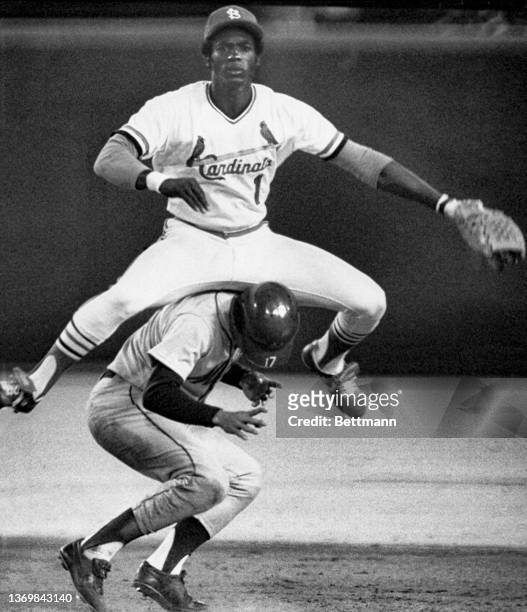 St. Louis Cardinals’ Garry Templeton leaps over New York Mets’ Felix Millan as he attempts to break up a double play in the eighth inning of the...