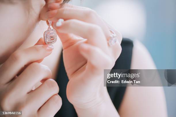 close up asian chinese woman put on earring jewelry - choker necklace stock pictures, royalty-free photos & images