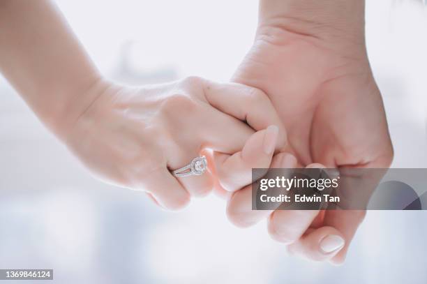 primo piano delle mani della coppia di sposi cinesi asiatici con la fede nuziale - engagement ring foto e immagini stock