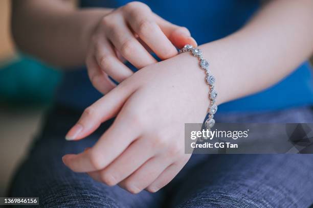 close up asian chinese teenage girl wearing bracelet with jewelry - bracelet stock pictures, royalty-free photos & images